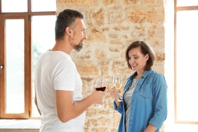 Photo of Couple with glasses of white and red wines indoors
