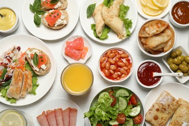 Buffet service. Many different dishes on white wooden table, flat lay