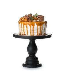 Dessert stand with delicious caramel cake on white background