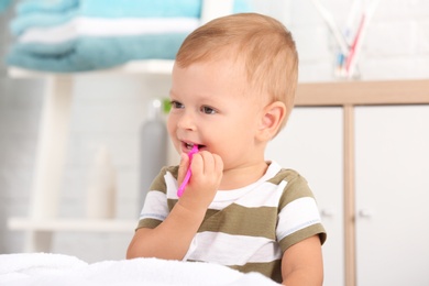 Photo of Cute little boy with toothbrush on blurred background