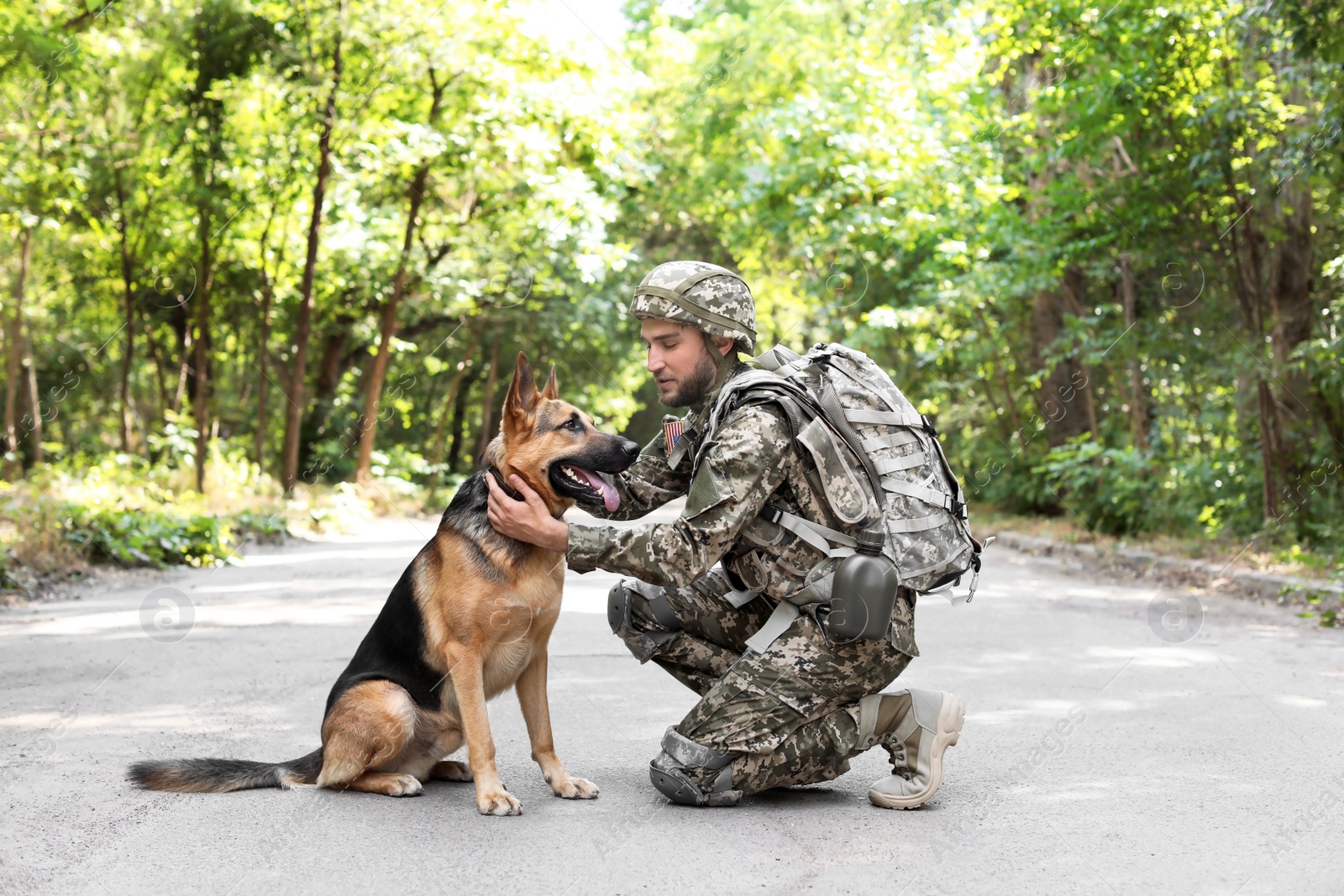 Photo of Man in military uniform with German shepherd dog outdoors