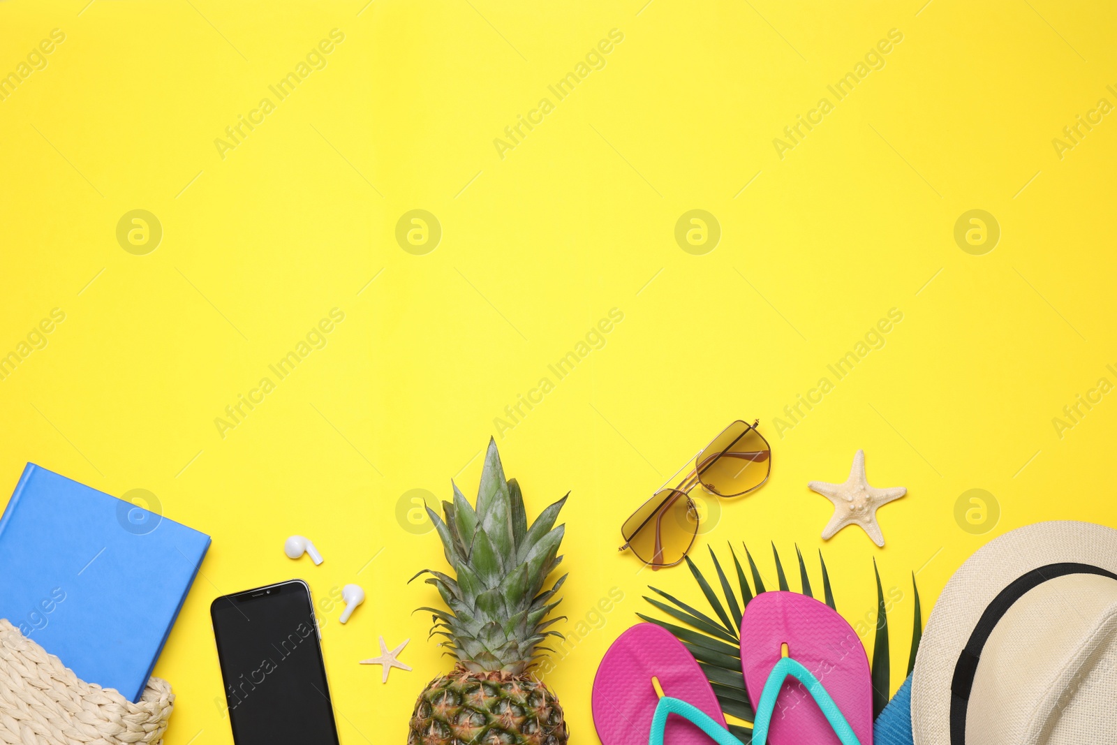Photo of Beach accessories on yellow background, flat lay. Space for text