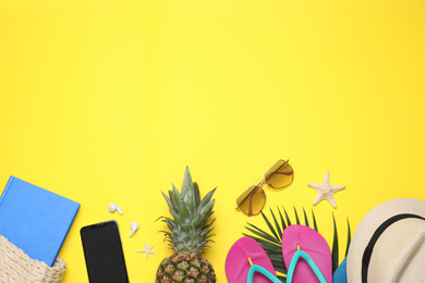 Beach accessories on yellow background, flat lay. Space for text