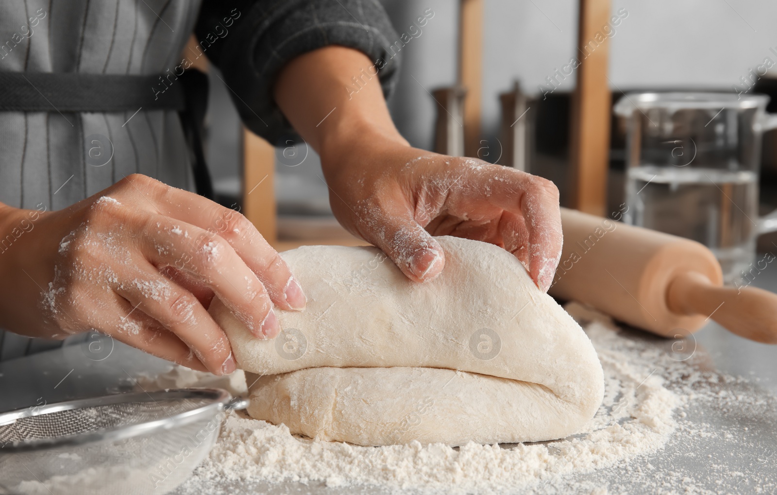 Photo of Woman kneading dough for pastry on table