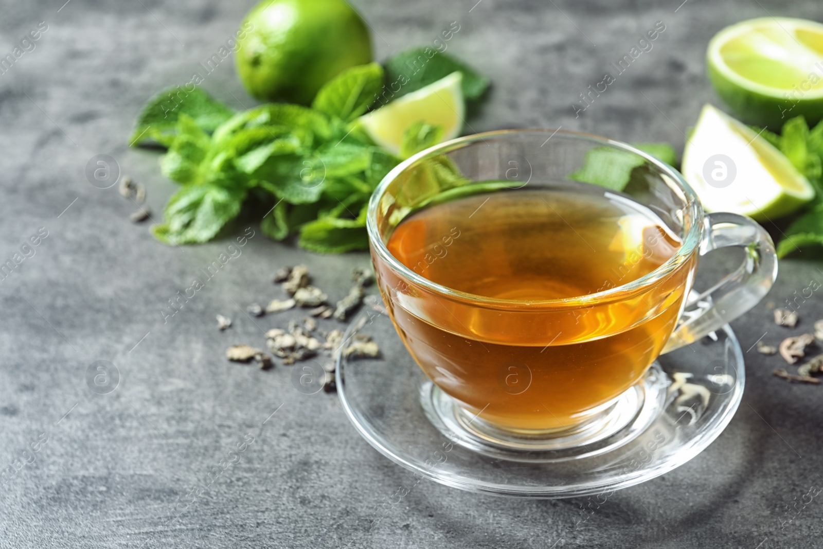 Photo of Cup with hot aromatic mint tea on table