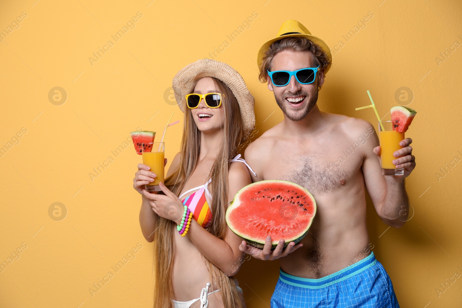 Photo of Young couple in beachwear with cocktails on color background