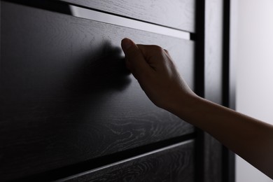 Photo of Woman knocking on door indoors, closeup view