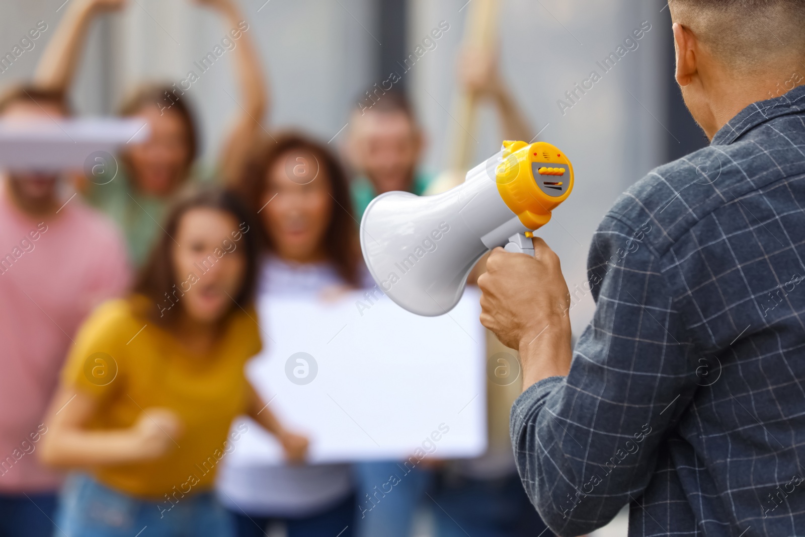 Image of Protest leader with megaphone talking to crowd outdoors