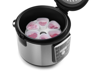 Open multi cooker with cups of homemade yogurt isolated on white