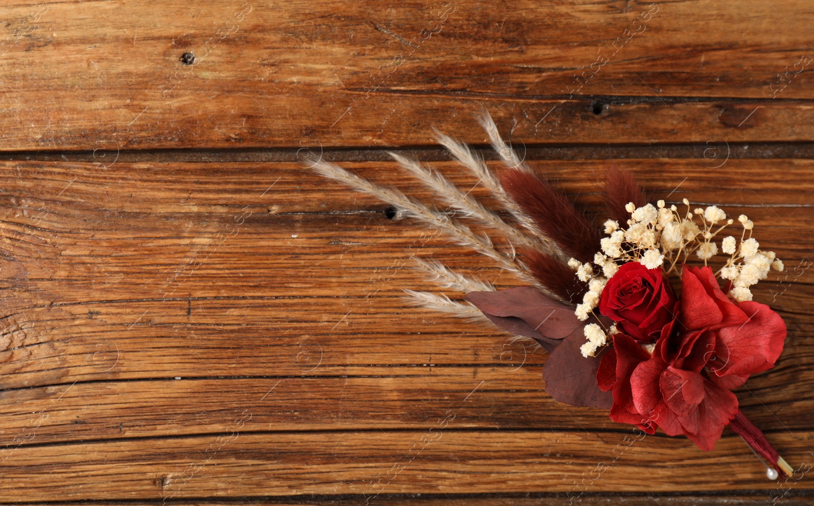 Photo of Beautiful boutonniere on wooden background, top view. Space for text