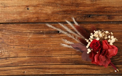 Photo of Beautiful boutonniere on wooden background, top view. Space for text