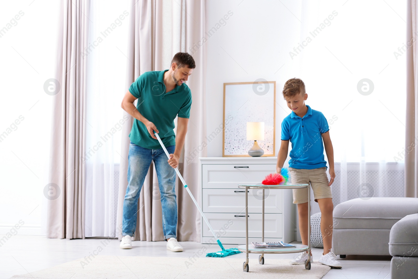 Photo of Dad and son cleaning living room together
