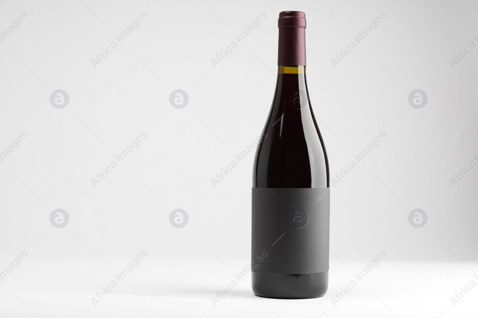 Photo of Bottle of tasty red wine on white background, space for text