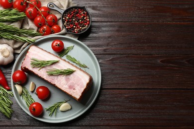 Photo of Piece of raw bacon with spices and cherry tomatoes on wooden table, flat lay. Space for text