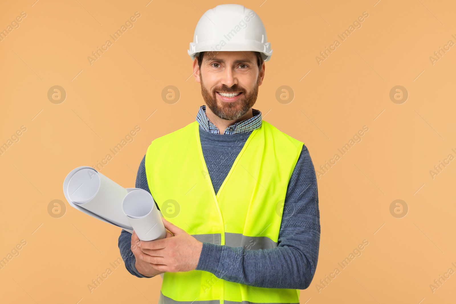 Photo of Architect in hard hat with drafts on beige background
