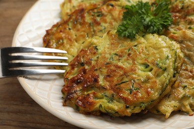 Photo of Delicious zucchini fritters served on table, closeup