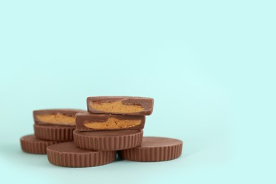 Photo of Sweet peanut butter cups on turquoise background. Space for text