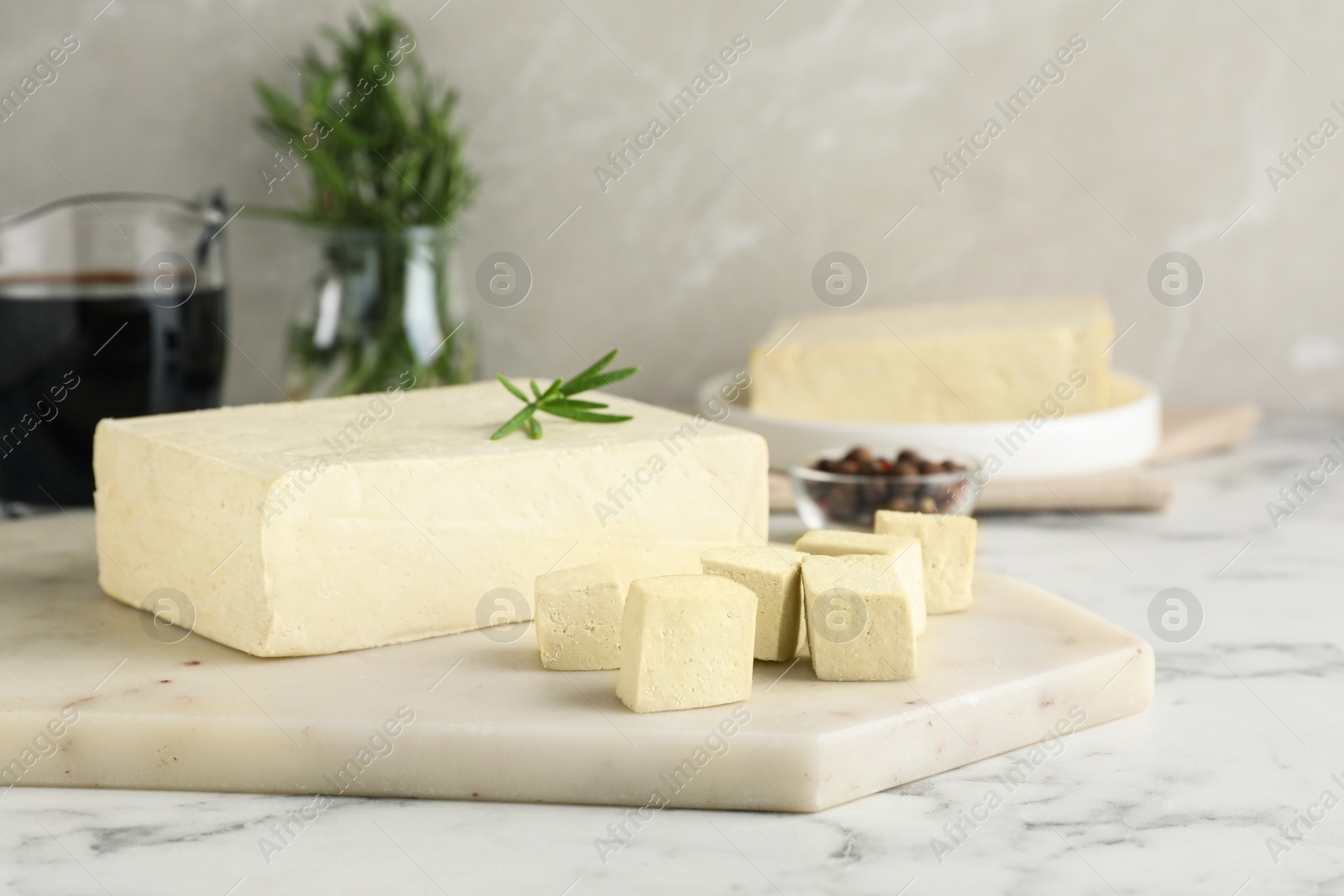 Photo of Delicious tofu with rosemary on white marble table