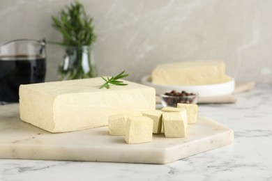 Photo of Delicious tofu with rosemary on white marble table