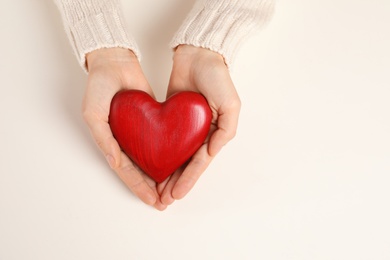 Photo of Woman holding decorative heart on white background, top view with space for text