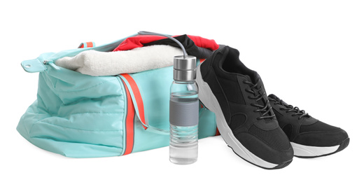 Sports bag with gym equipment on white background