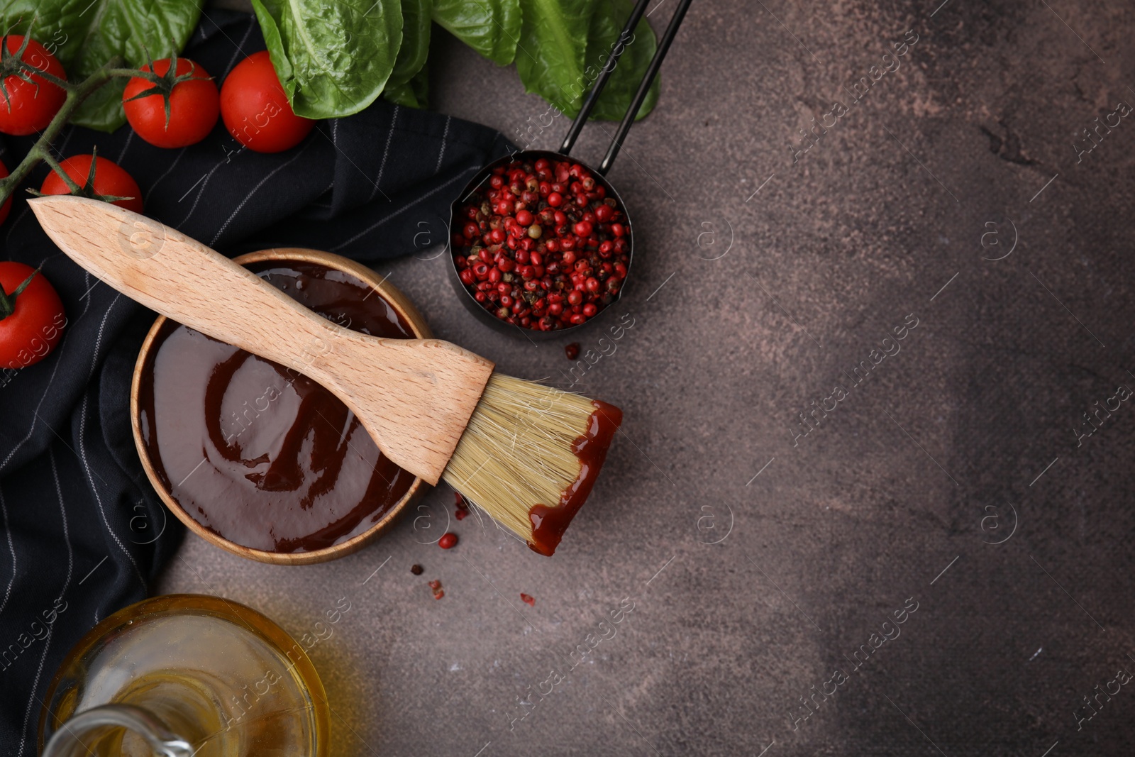 Photo of Flat lay composition with marinade in bowl and basting brush on brown table. Space for text