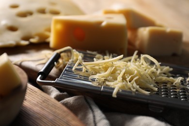 Grated, cut cheese and grater on table, closeup