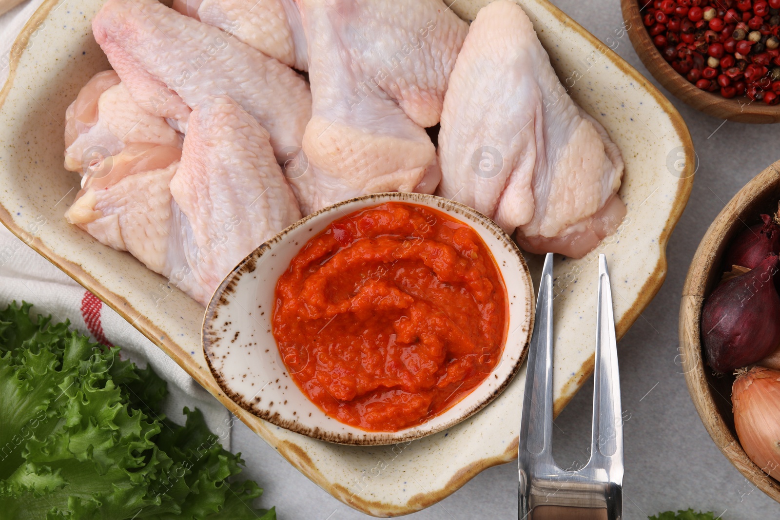 Photo of Flat lay composition with marinade, raw chicken and other products on light table