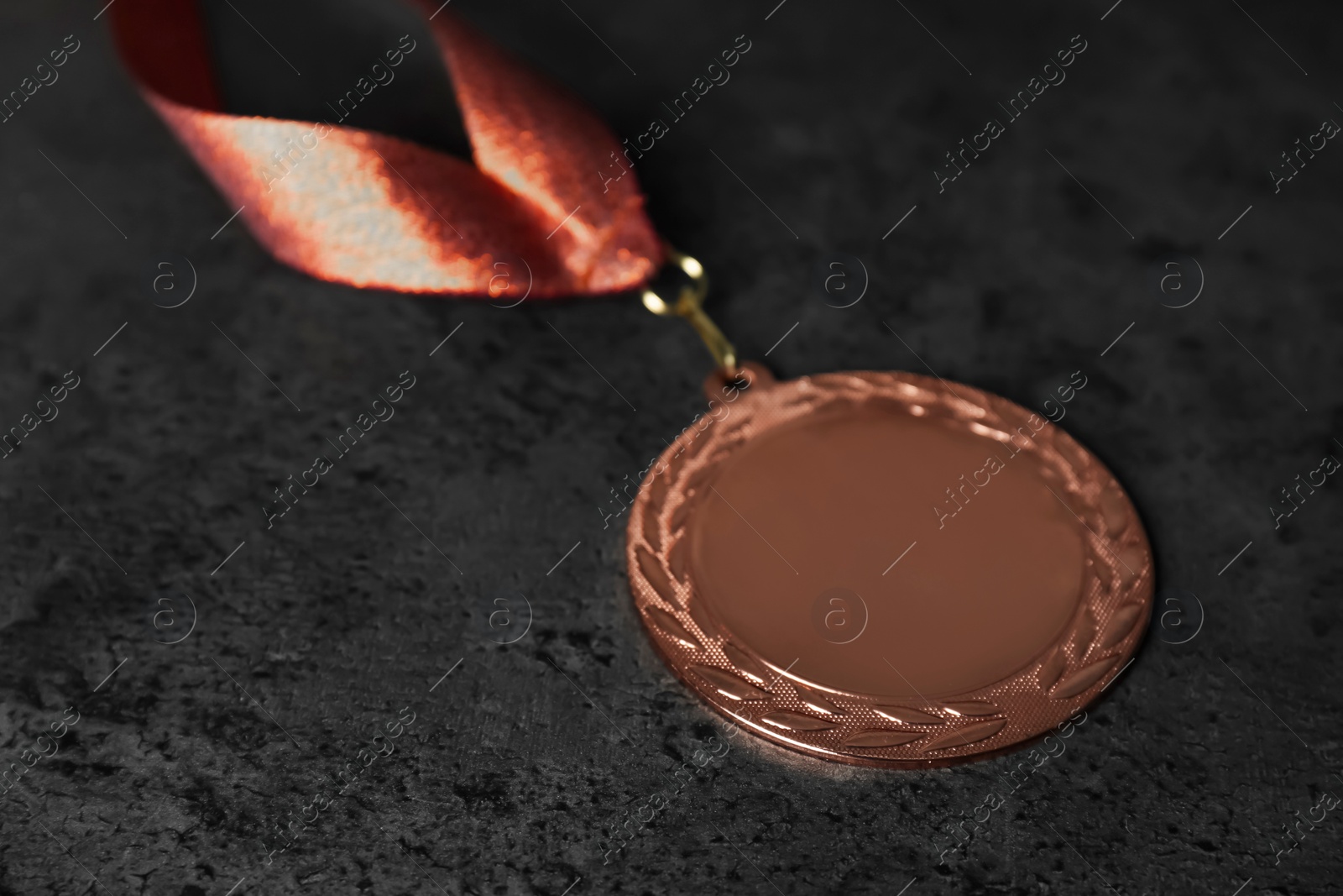 Photo of Bronze medal on grey stone background. Space for design