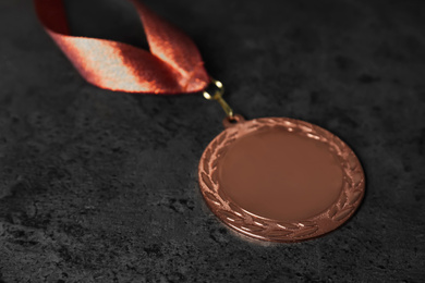 Photo of Bronze medal on grey stone background. Space for design