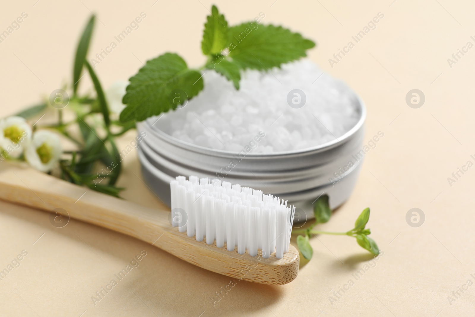 Photo of Toothbrush, salt and herbs on beige background, closeup.