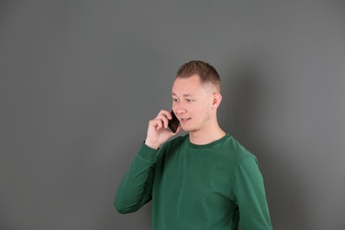 Photo of Portrait of handsome man with mobile phone on color background