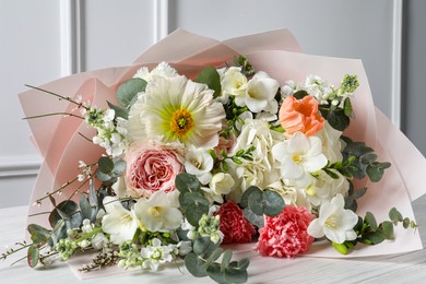 Bouquet of beautiful flowers on white wooden table, closeup