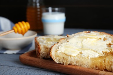 Slices of bread with butter, honey and milk on grey wooden table, closeup