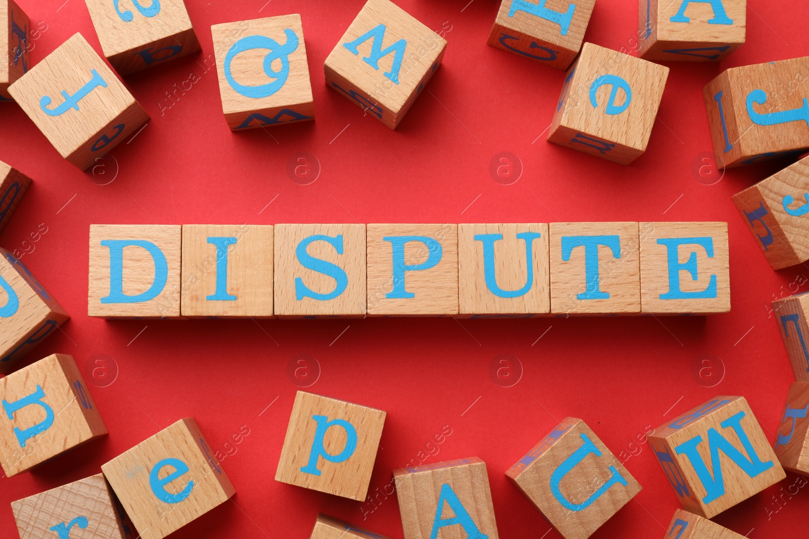 Photo of Cubes with word Dispute on red background, flat lay