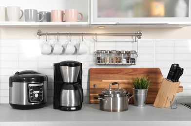 Photo of Different appliances, clean dishes and utensils on kitchen counter