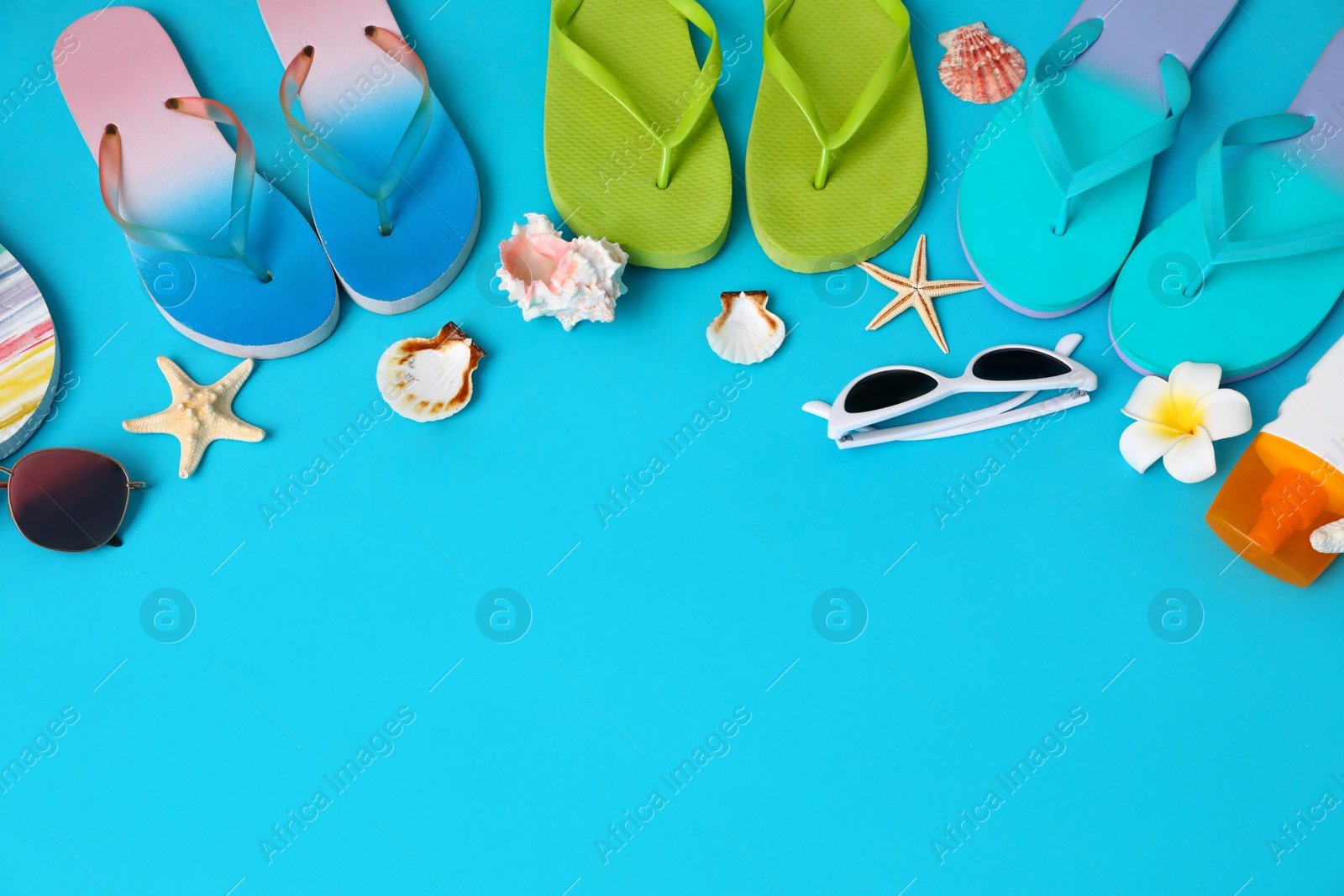 Photo of Flat lay composition with different flip flops on blue background, space for text. Summer beach accessories