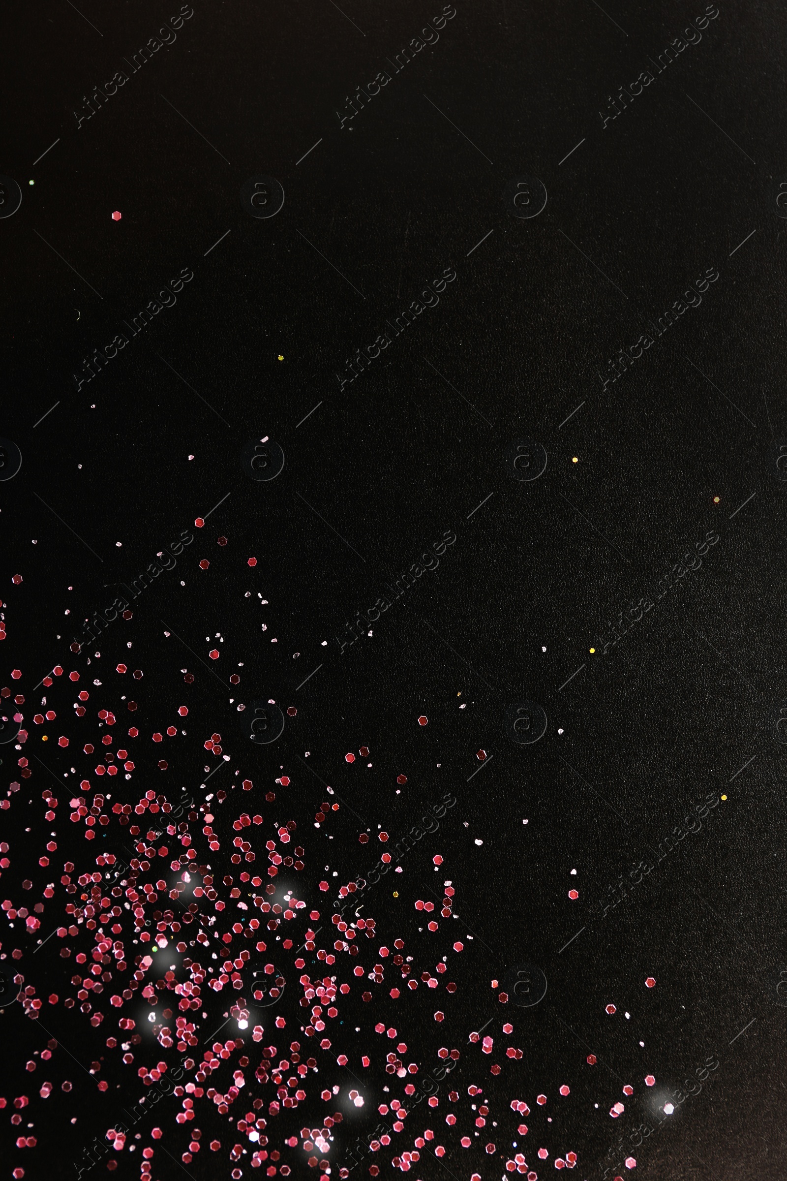 Photo of Rose gold glitter on black background, top view with space for text