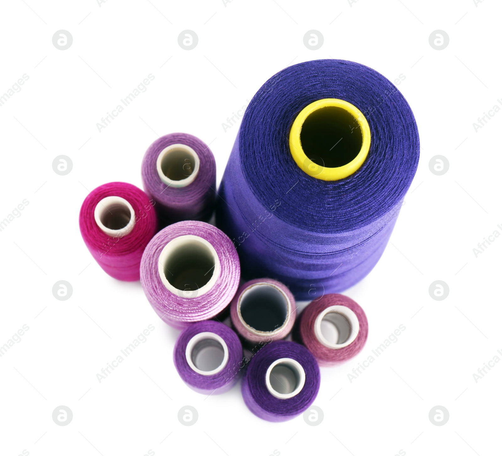 Photo of Set of colorful sewing threads on white background, top view