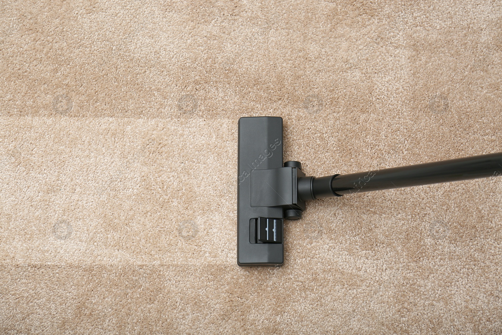 Image of Vacuuming dirty beige carpet. Clean area after using device, top view