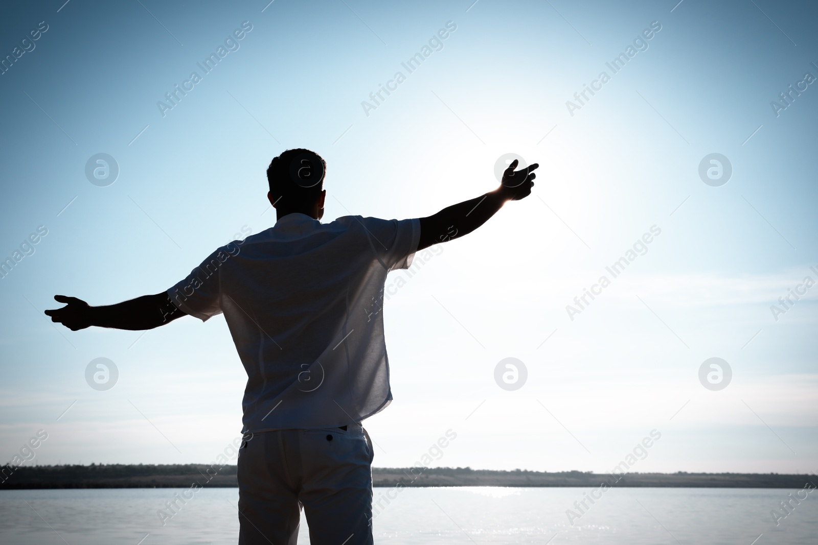 Photo of Man near river at sunset, back view. Nature healing power