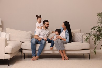 Photo of Happy family resting on sofa in living room