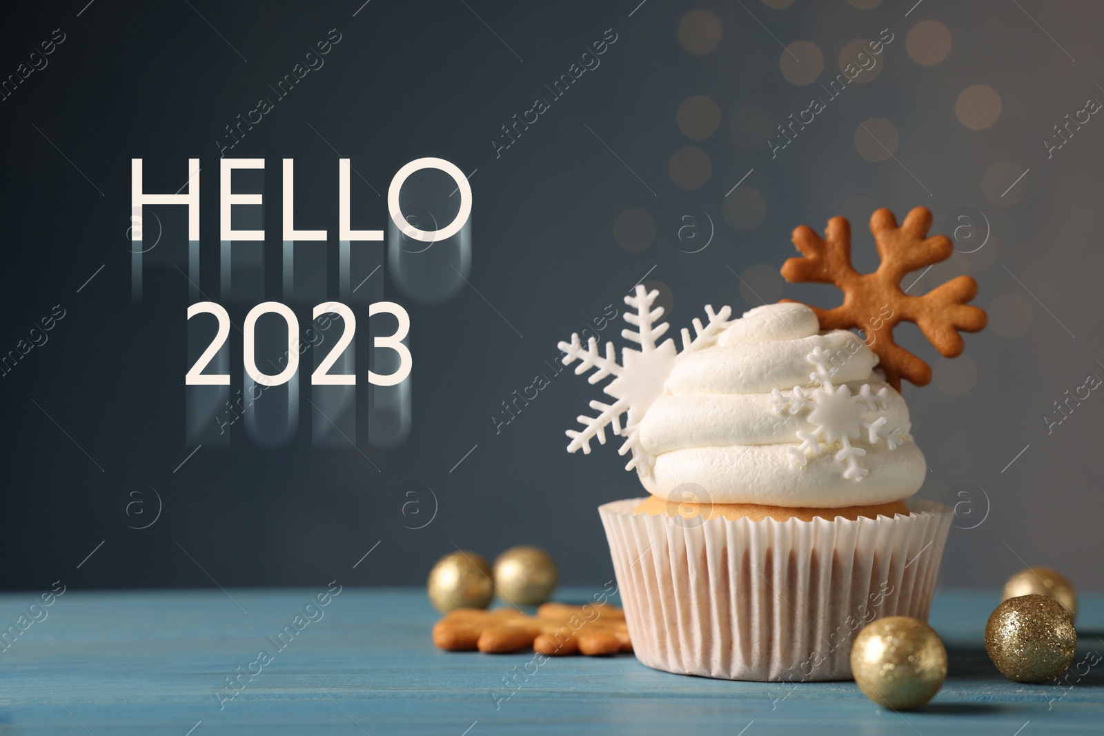 Image of Hello 2023. Tasty Christmas cupcake with snowflakes and festive decor on light blue wooden table