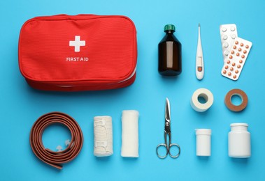 Photo of Flat lay composition with first aid kit on light blue background