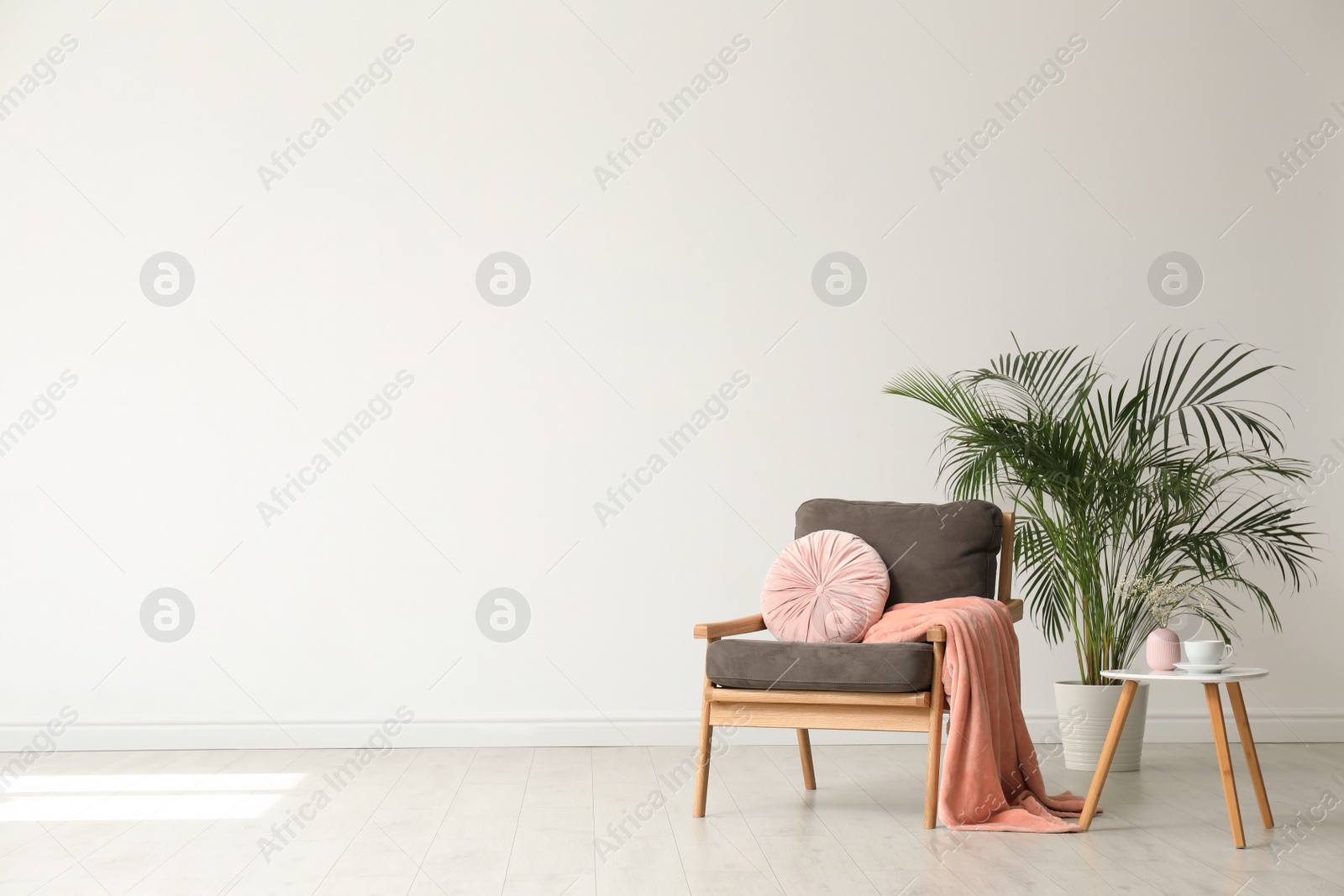 Photo of Stylish living room interior with comfortable armchair and houseplant white wall. Space for text