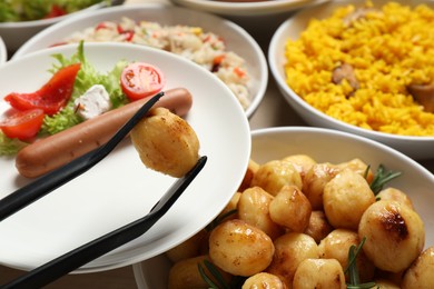 Taking roasted potato from buffet table, closeup