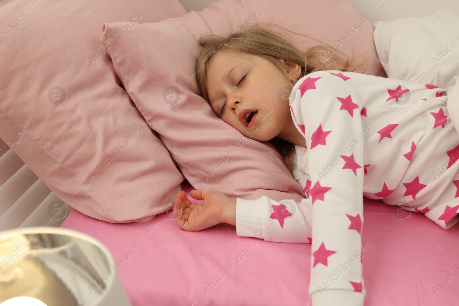 Photo of Little girl snoring while sleeping in bed