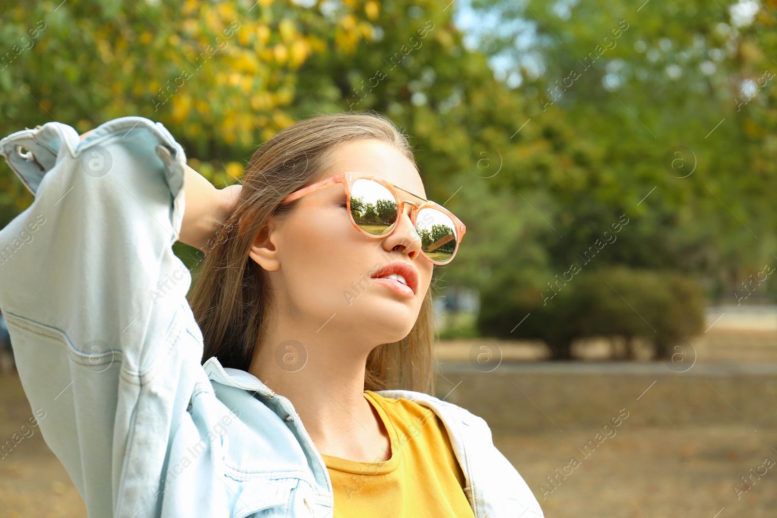 Photo of Young woman wearing stylish sunglasses in park