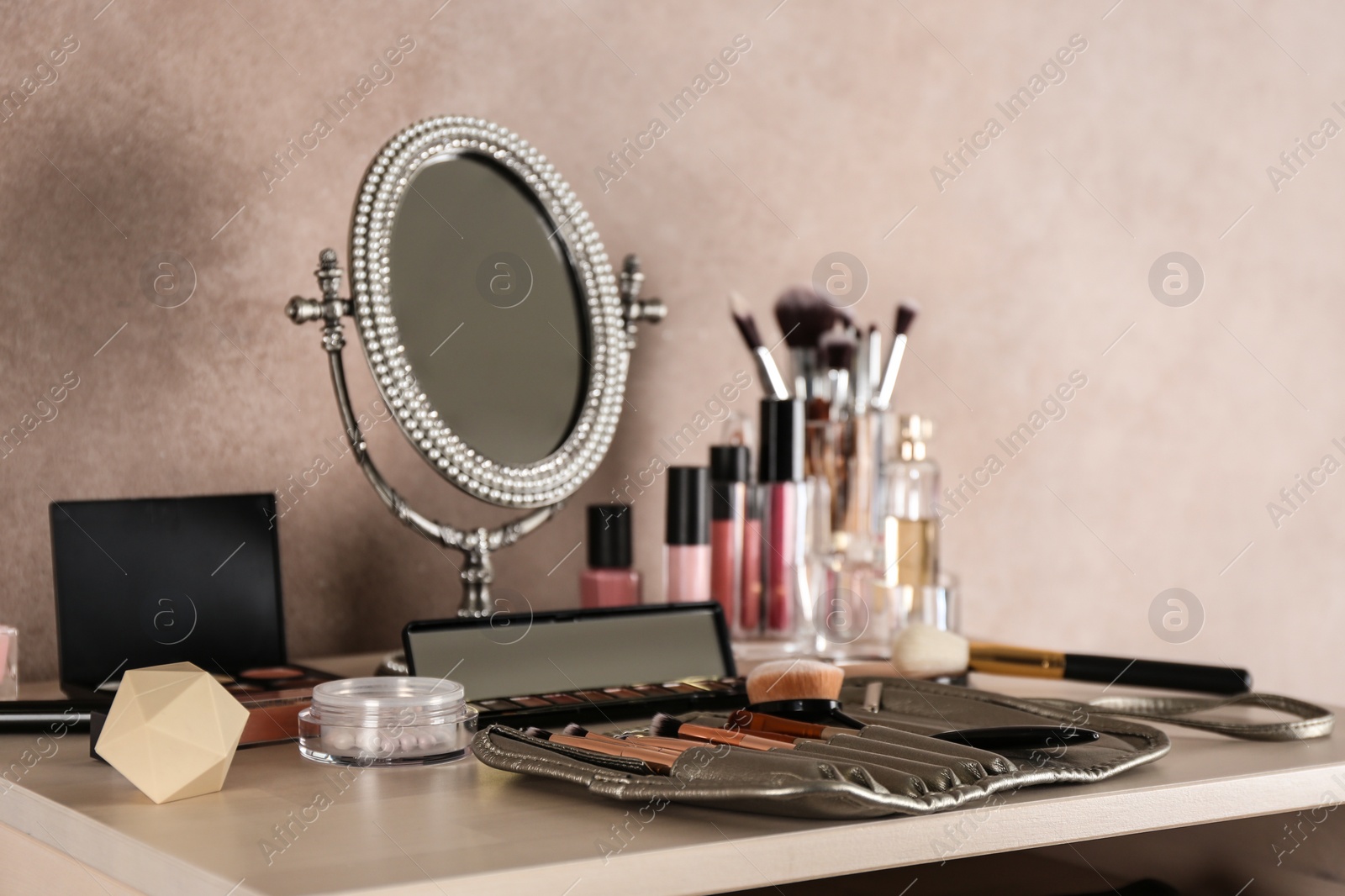 Photo of Dressing table with beauty accessories near color wall in room