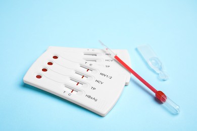 Photo of Disposable express hepatitis test kit on light blue background
